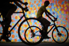 Bicyclists cruise along the Beltline past a mural by HENSE under Virginia Avenue.